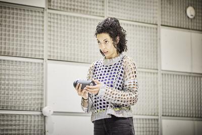Une jeune femme parle à une enceinte musicale bluetooth