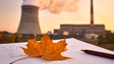 Une feuille d'arbre posée sur une lettre manuscrite. En arrière plan, des cheminées d'usine.