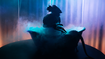 Une créature sous-marine hybride dans une baignoire, sur scène.